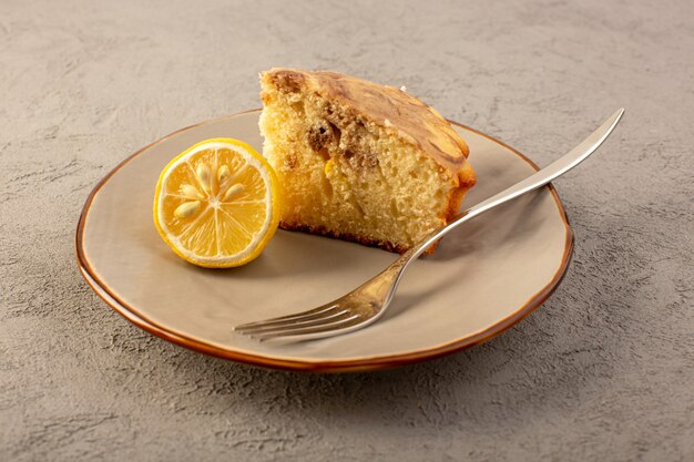 Un avant fermé vue morceau de gâteau sucré délicieux délicieux gâteau choco en tranches à l'intérieur de la plaque beige avec morceau de citron