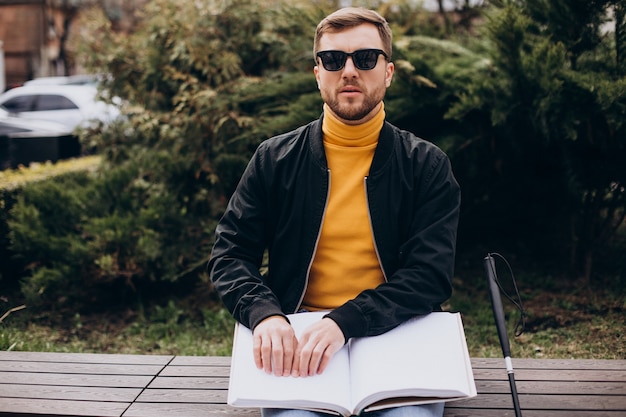 Aveugle lisant en touchant le livre en braille