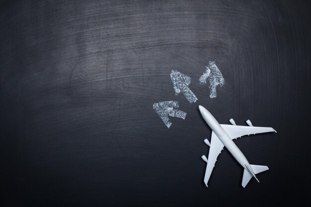 Avion jouet sur fond de tableau et dessins de flèches