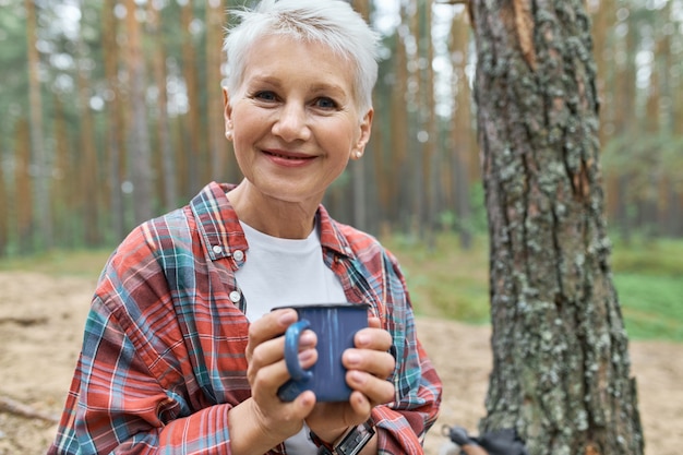 Avis d'adorable retraité femme européenne heureuse avec des cheveux blonds ayant reste à l'extérieur au camping