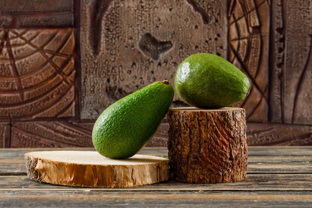 Avocat savoureux dans des morceaux de bois sur une table en bois