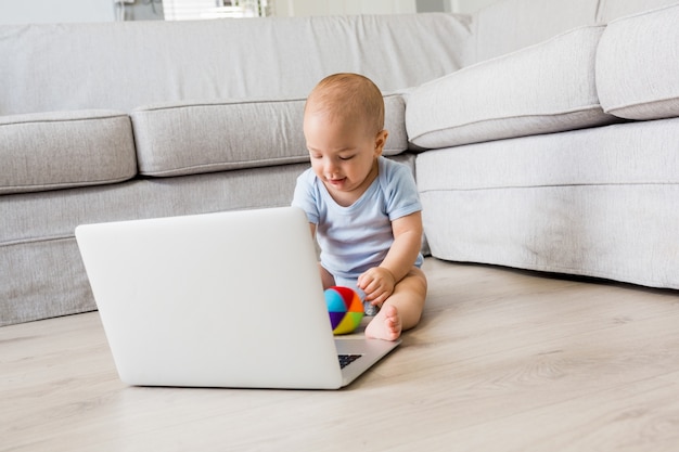 Baby boy assis sur le plancher et en jouant avec des jouets dans le salon