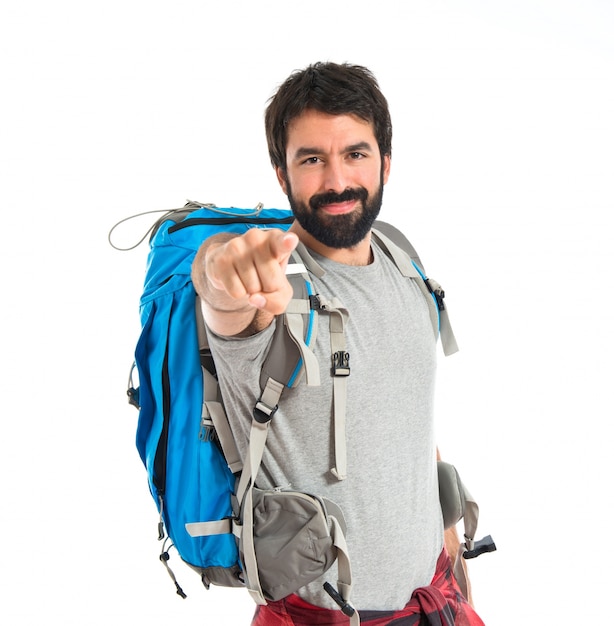 Backpacker pointant vers l&#39;avant sur fond blanc