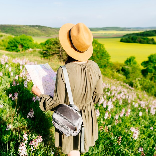 Backview de femme sur le terrain en regardant la carte