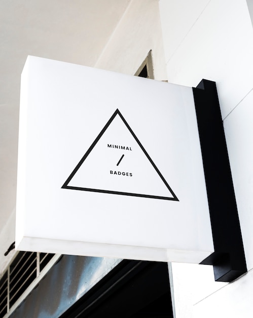 Badge triangulaire minimal sur une maquette de panneau blanc