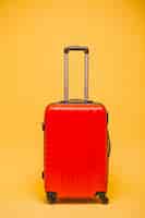 Photo gratuite bagages rouges sur fond jaune isolé