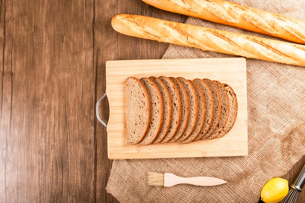 Bagel Et Tranches De Pain Noir Sur Planche De Cuisine