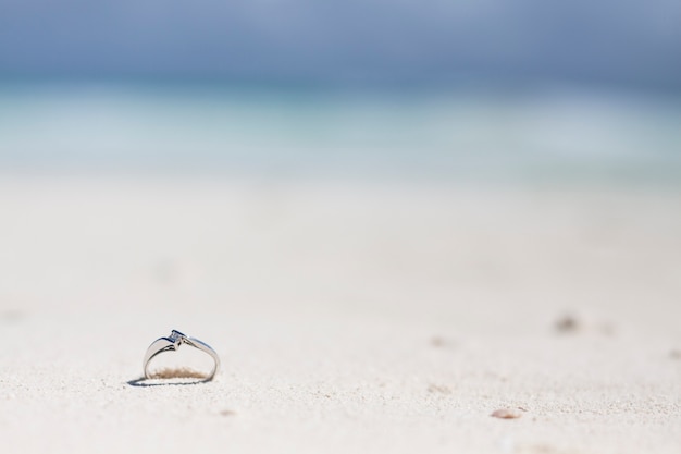 Bague de fiançailles en gros plan dans le sable