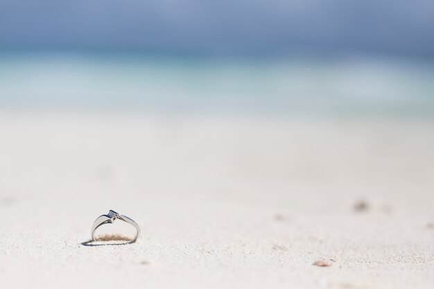 Bague de fiançailles en gros plan dans le sable