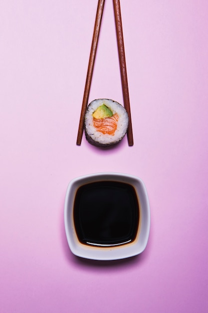 Photo gratuite baguettes aux sushis près de la sauce soja