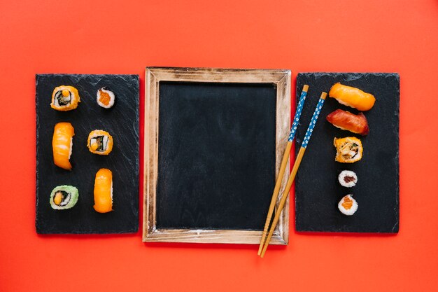 Baguettes sur le tableau noir entre les conseils de sushi