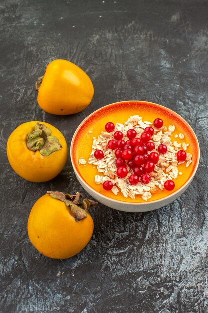 Baies baies dans un bol orange trois kakis appétissants