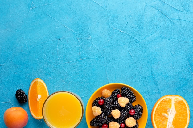 Photo gratuite baies fraîches à plat et fruits avec fond