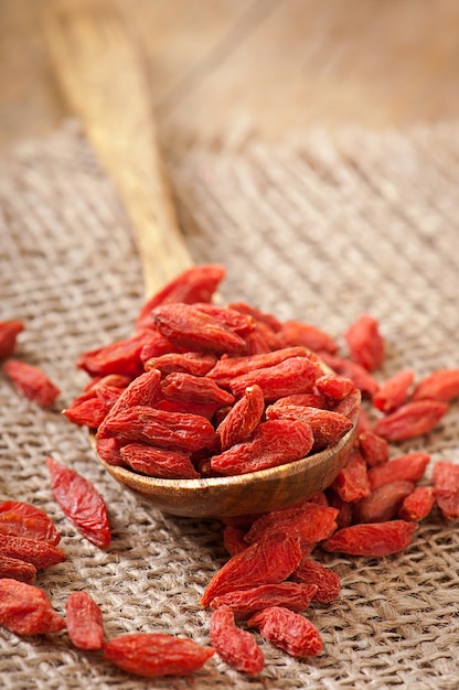 Baies de goji séchées rouges dans une cuillère en bois