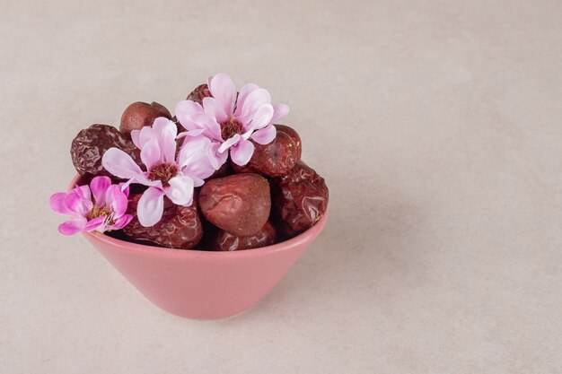 Baies de jujube séchées dans une tasse sur du béton.