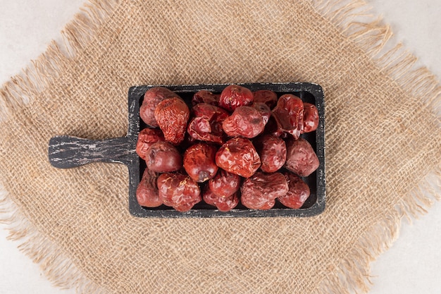 Photo gratuite baies de jujube séchées sur un plateau en bois rustique.