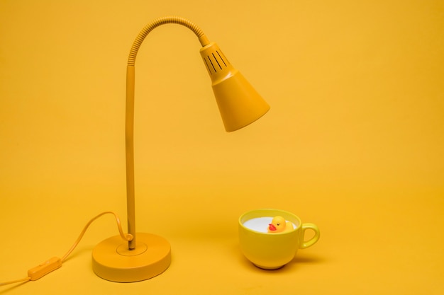 Bain de canard dans une tasse de lait sous une lampe