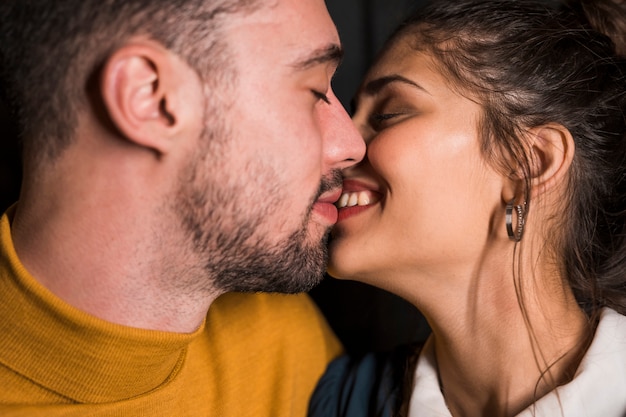 Photo gratuite baiser de jeune homme et dame souriante