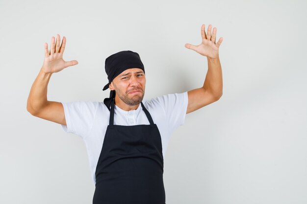 Photo gratuite baker homme levant les mains dans un geste impuissant en t-shirt