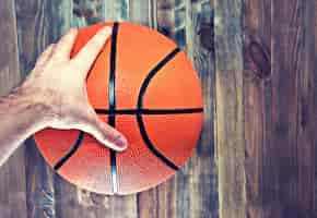 Photo gratuite balle de basketball sur le bois dur en bois agrippant à la main.