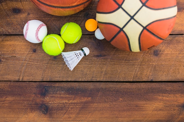 Balle de ping pong; base-ball; volant; ballon de basket et de tennis sur planche de bois