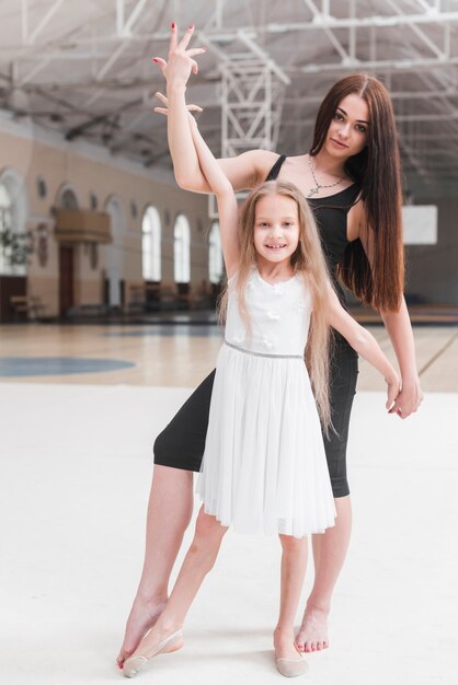 Ballerina instructeur avec son élève qui pose en cours de danse