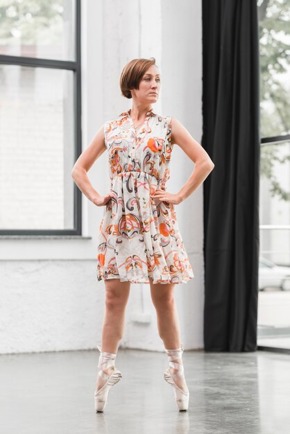 Ballerine féminine en robe florale debout sur des chaussures de pointe