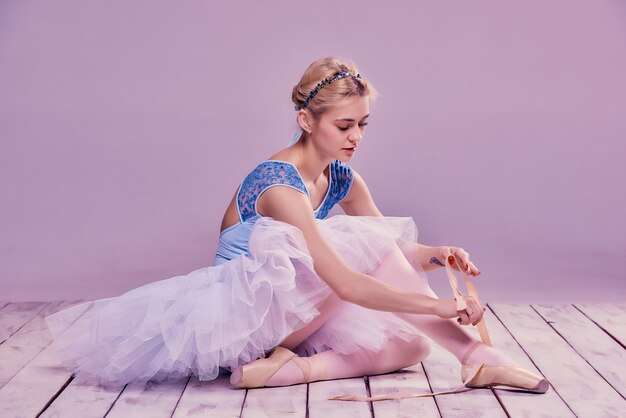 Ballerine professionnelle mettant ses chaussures de ballet.