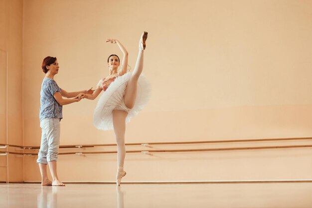 Ballerine souriante dansant avec l'aide d'une instructrice sur un cours de ballet dans un studio Espace de copie