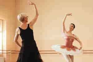Photo gratuite ballerine souriante et son instructeur répétant dans un studio de ballet