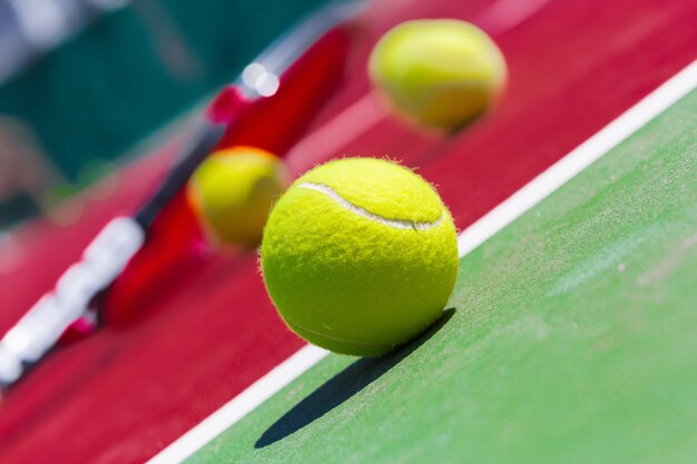 Balles de tennis et raquette sur le gazon