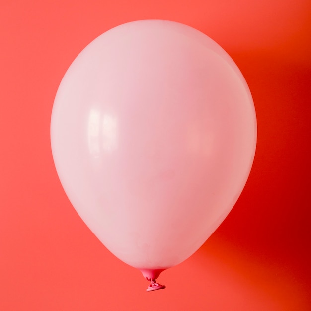 Ballon rose sur fond rouge