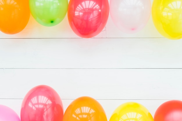 Ballons colorés sur une table en bois blanche