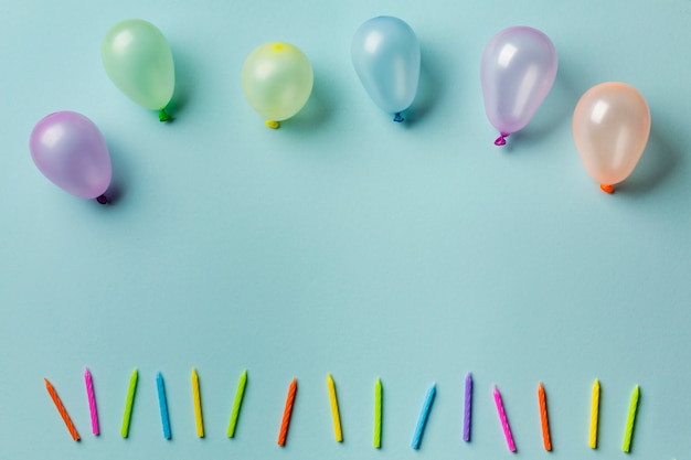 Ballons sur la rangée de bougies colorées sur fond bleu