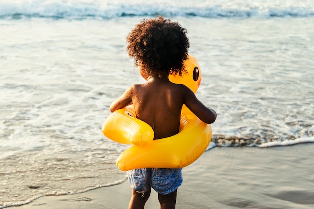 Bambin mignon avec tube de canard sur la plage