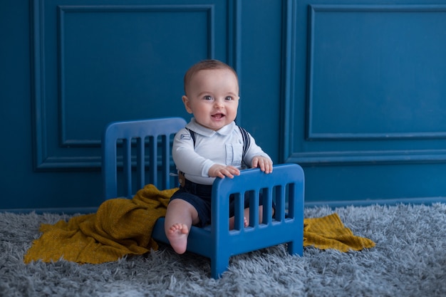 Un bambin avec une tenue élégante à l'intérieur d'un lit décoratif dans la chambre.