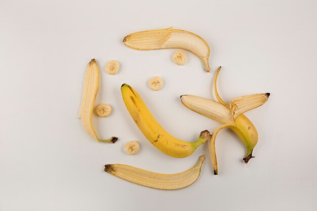 Bananes pelées et tranchées sur fond blanc, vue du dessus