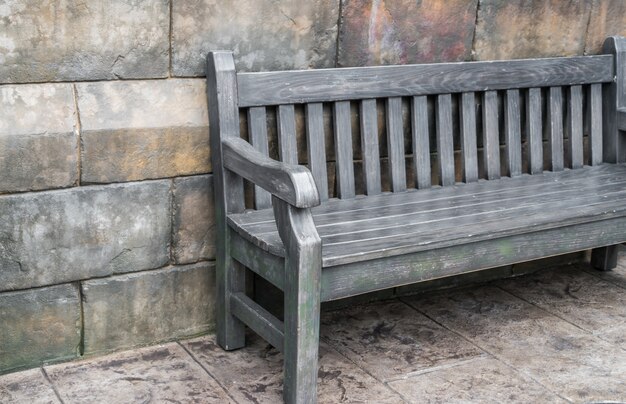 Banc de bois contre le mur de béton.