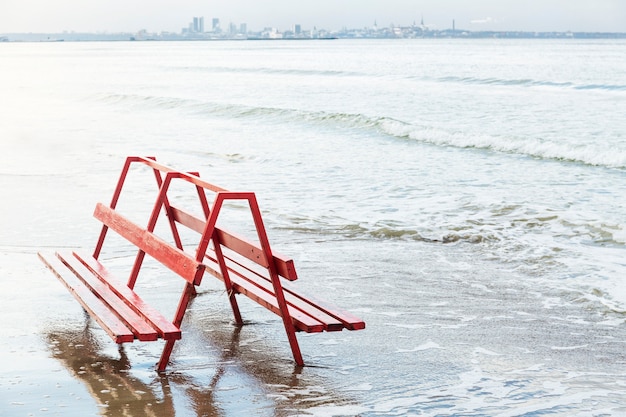 Banc rouge près de la mer agitant