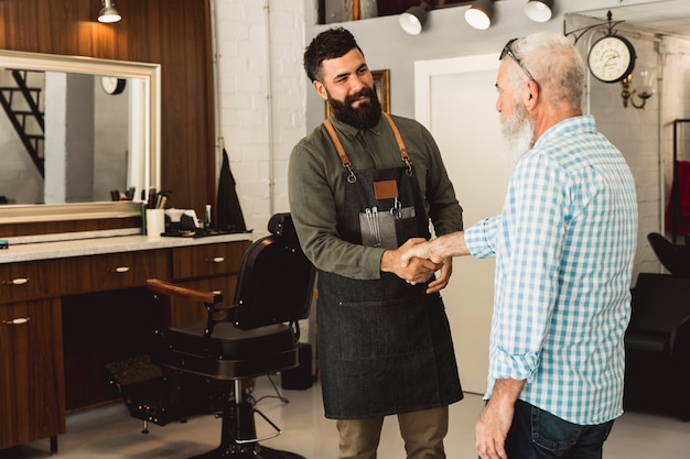 Barber et un client âgé se serrant la main