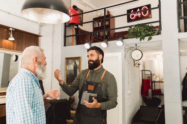 Barber, conversation, à, vieux client, dans, salon coiffure