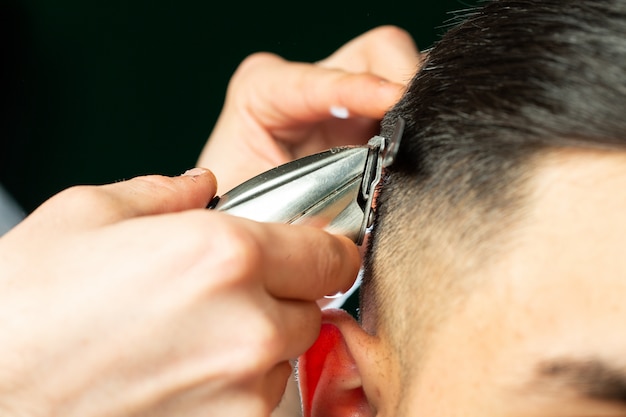 Barber fait la coupe de cheveux avec la machine de coupe