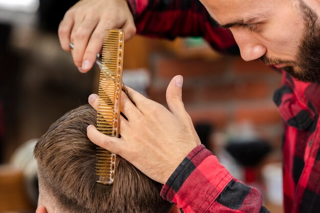 Barbier mesurant les cheveux avec un peigne