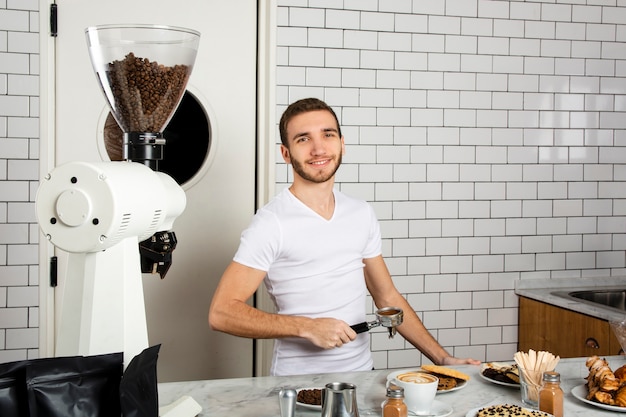 Barista tenant dans la main une cuillère à expresso avec de la poudre de café