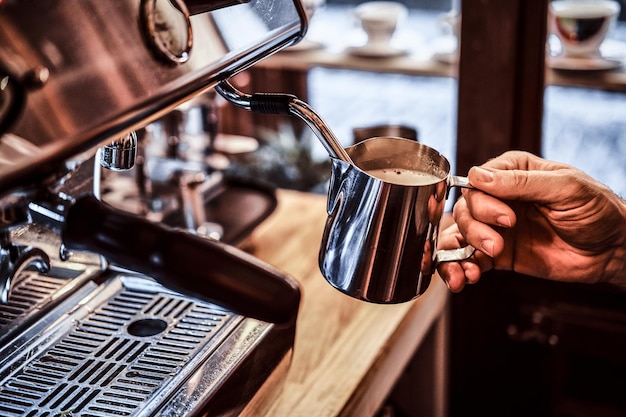 Le barista travaillant sur une machine à café expresso à vapeur dans un café