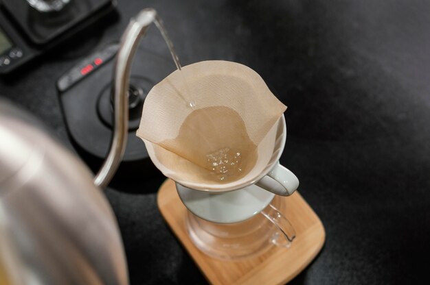Barista versant de l'eau bouillante dans un filtre à café