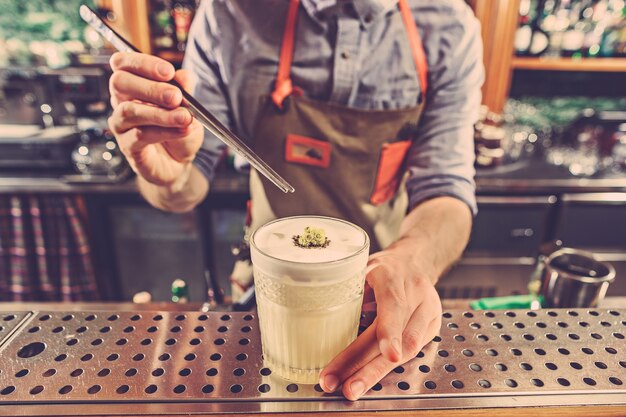 Un barman expert prépare un cocktail en boîte de nuit.