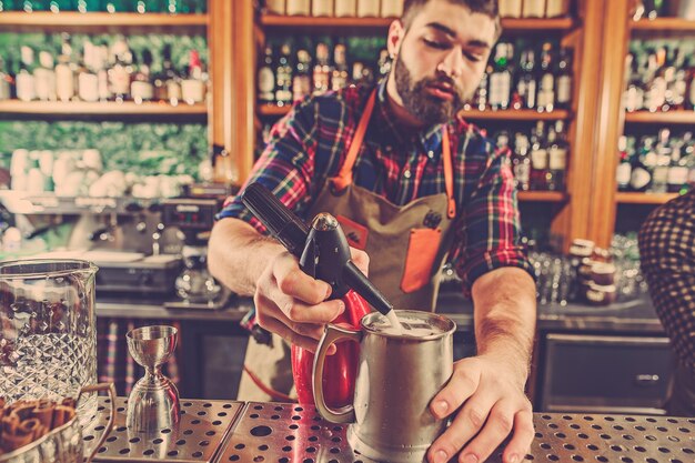 Barman faisant un cocktail alcoolisé au comptoir du bar sur le bar