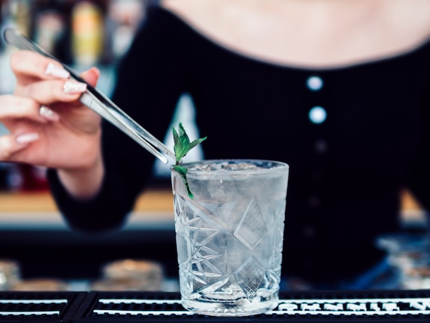 Barman femme décorer un verre à cocktail