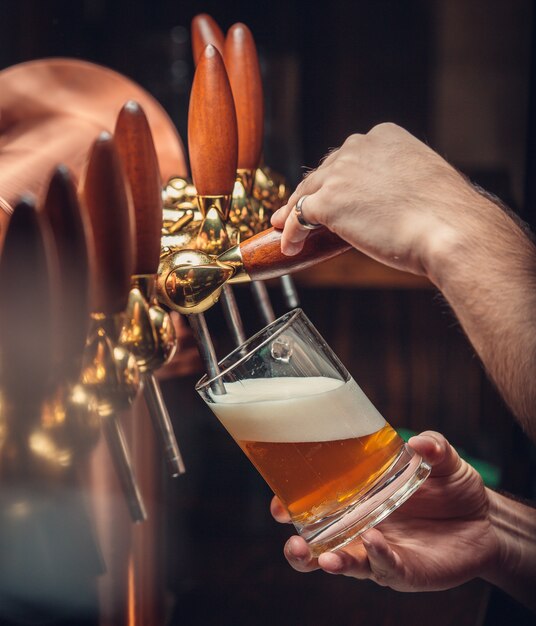 Barman mettant la bière en verre.